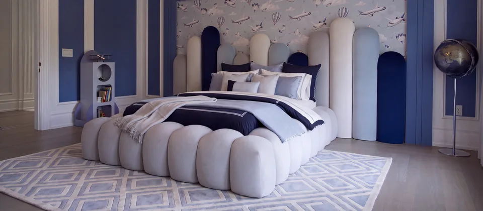 Sculptural upholstered bed with a blue and cream headboard